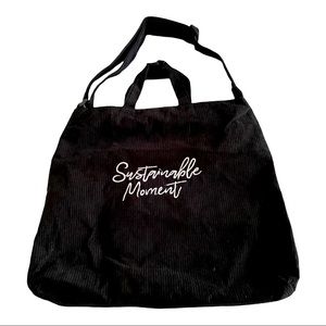 Black corduroy bag with zipper closure and adjustable strap. Brand new.